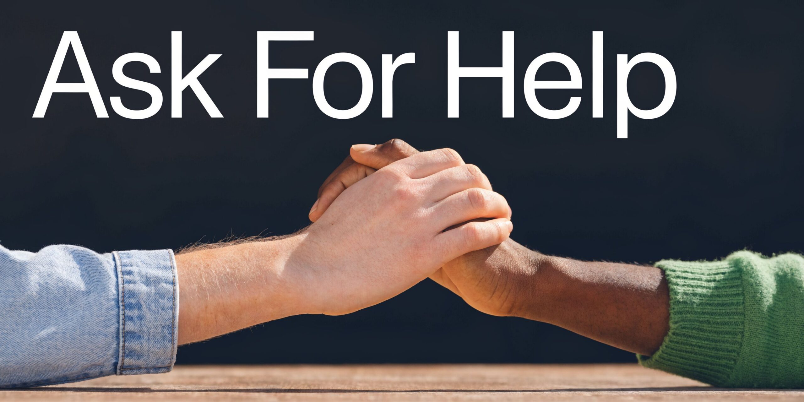Two people of different skin tones holding hands together against a dark background with text overlay.