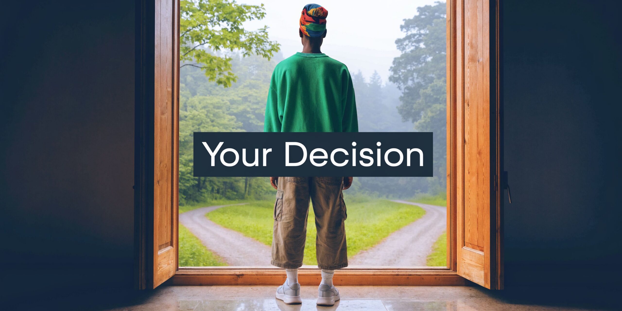 A person standing in an open doorway looking at a fork in a path through the forest.