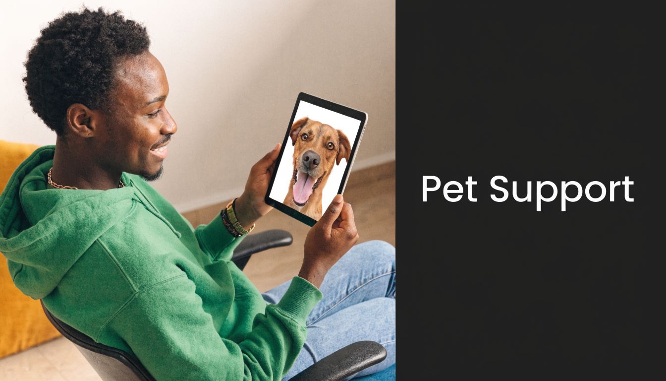 A happy young man holding a tablet displaying an image of a smiling dog for pet support.