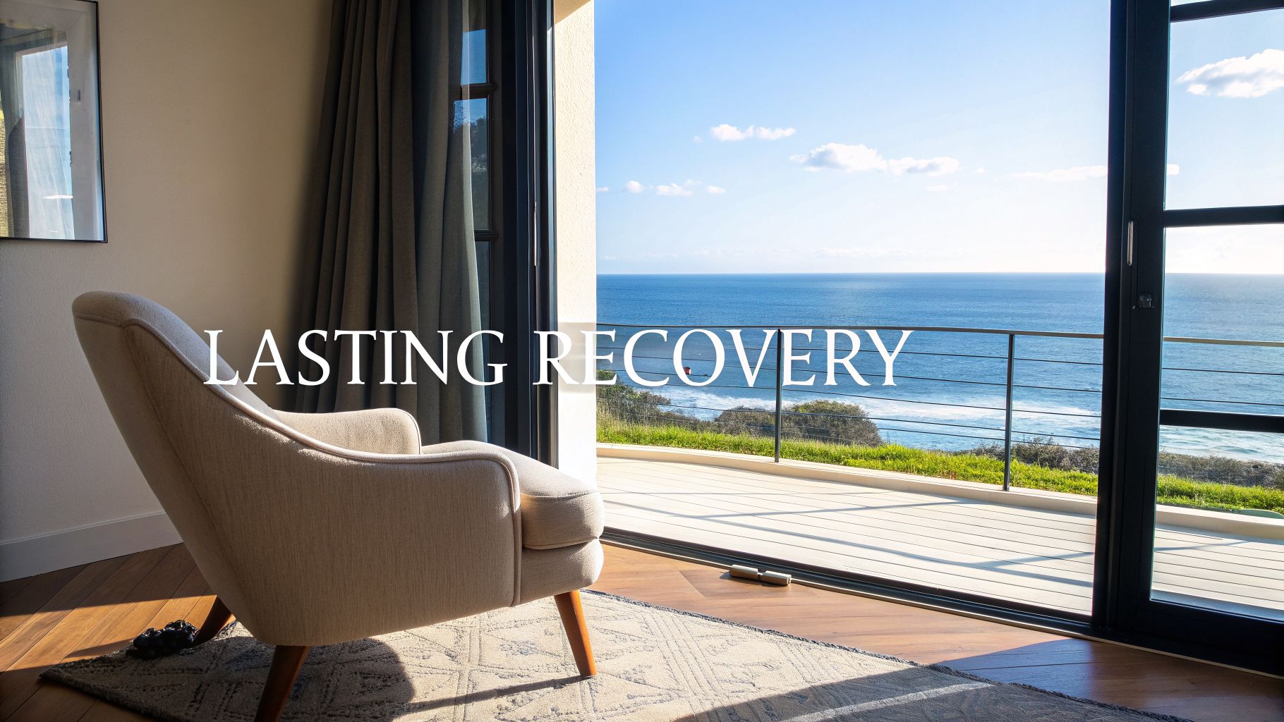 A cozy armchair in a sunlit room with a stunning ocean view and a balcony.