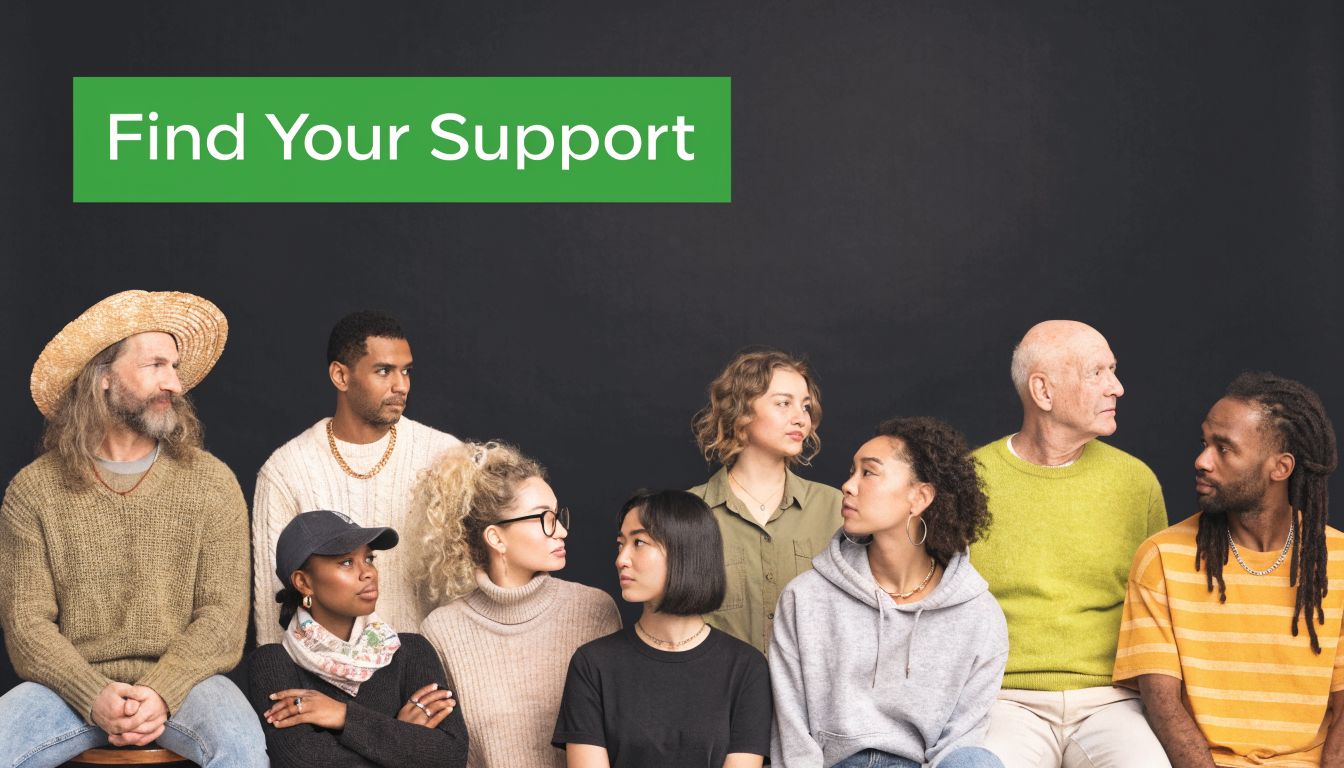 A diverse group of people sitting together against a black background with a green support sign.